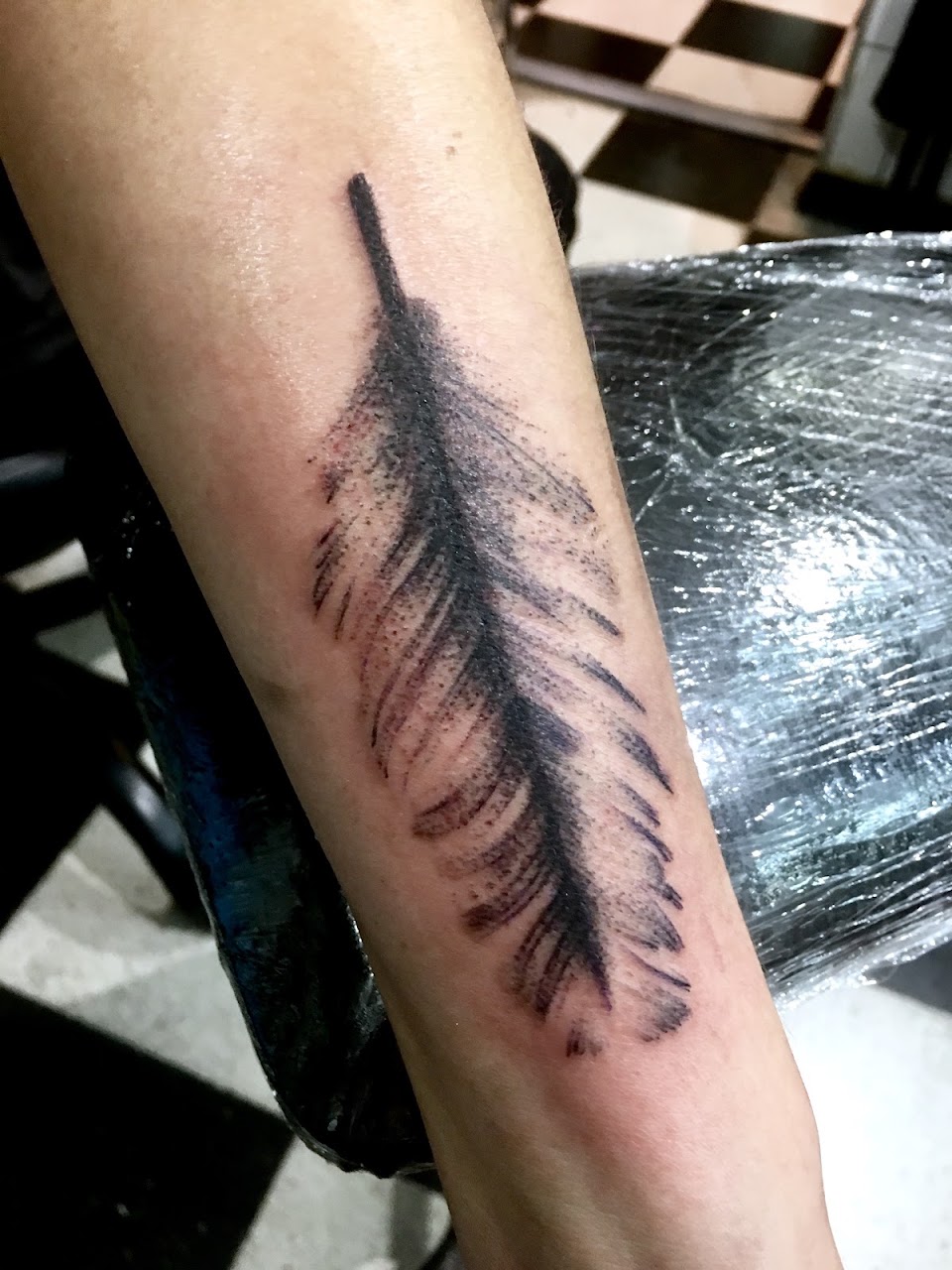 Tatuaje de pluma en antebrazo